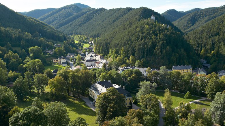 Aerial view of Gutenstein with green hills and a castle on a hill.