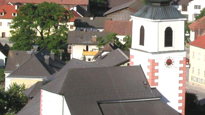 Hochneukirchen parish church with surrounding buildings and landscape.
