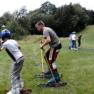 People skiing on grass in a meadow.