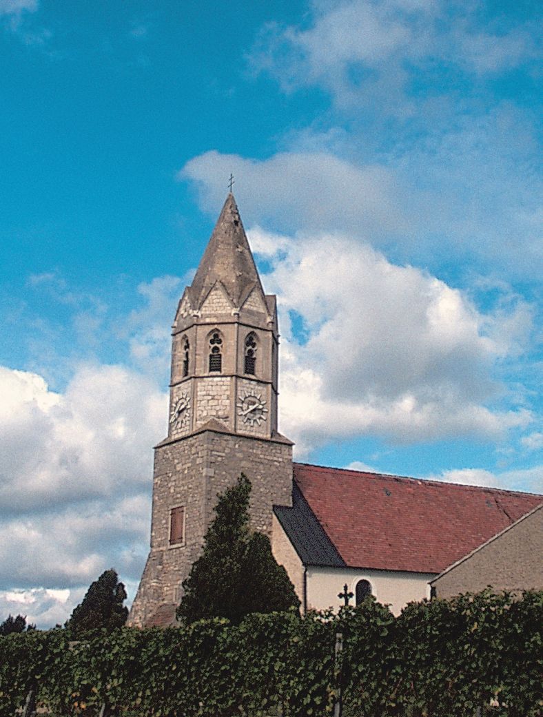 Church with tower and clock against a blue sky.