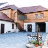 Inner courtyard of a guest house with wooden elements and paved floor.