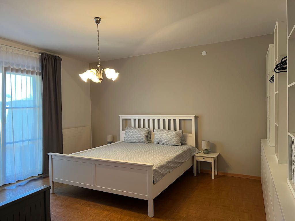 Bedroom with white bed, bedside table and closet.