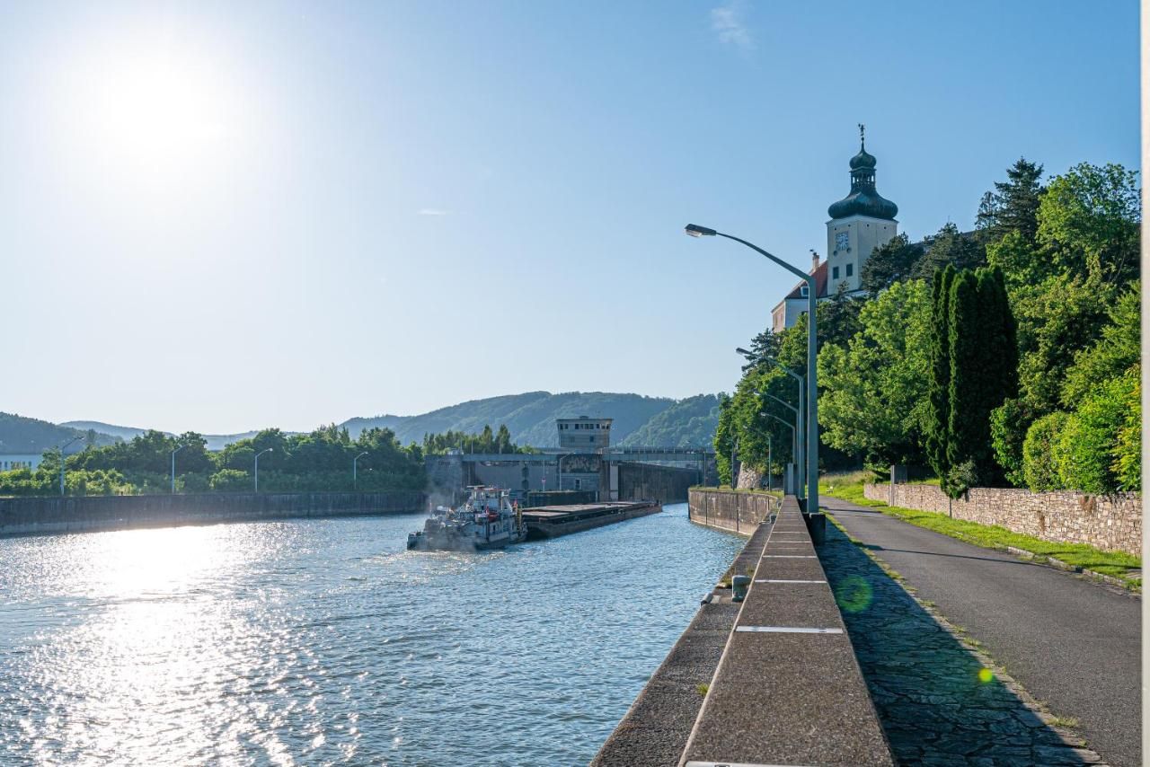 River with ship and building on the bank, sunny sky.