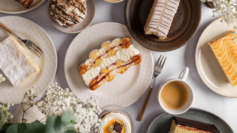 Various pieces of cake and a cup of coffee on a table.