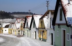 In dieser malerischen Gasse, umgeben von schneebedeckten Dächern, strahlt die winterliche Idylle eine ruhige Gemütlichkeit aus. Die bunten Fassaden der Hütten laden dazu ein, die Schönheit der Natur zu genießen und die frische, klare Luft zu atmen.