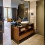 Modern hotel room with open bathroom and shower.