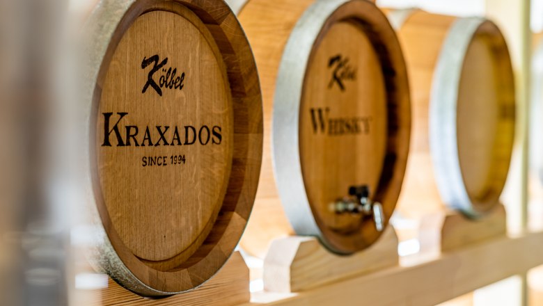 Large wooden barrels labeled "Kraxados" and "Whiskey" in a storage room.