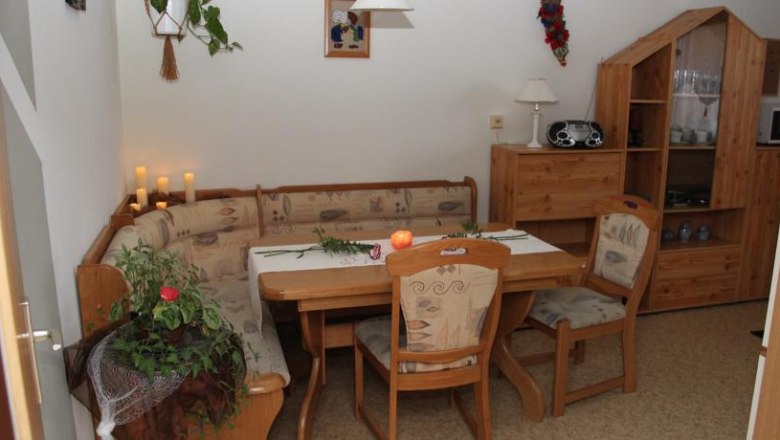Cozy dining area with wooden furniture and corner bench.