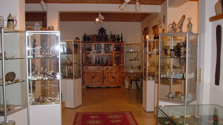 Interior view of a museum with glass showcases full of pipes and collector's items.