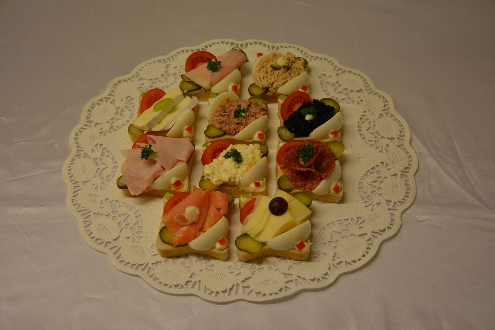 A plate of sandwiches on a lace tablecloth.