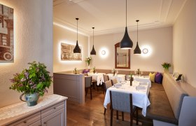 Elegant restaurant with laid tables, modern lamps and flower arrangements.