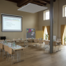 A bright room with a U-shaped table setup for an innovation workshop. 'Innovation workshop' is written on a screen.