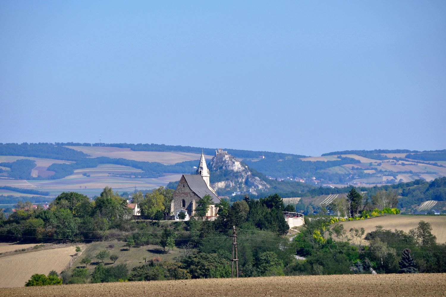 Landscape with church and hill in the background.