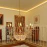 Elegant chandelier in a stylish room with paintings and furniture.