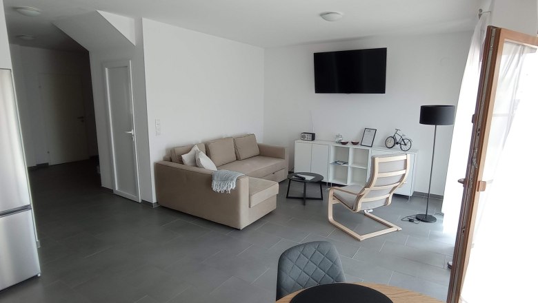 Living room with beige couch and white walls