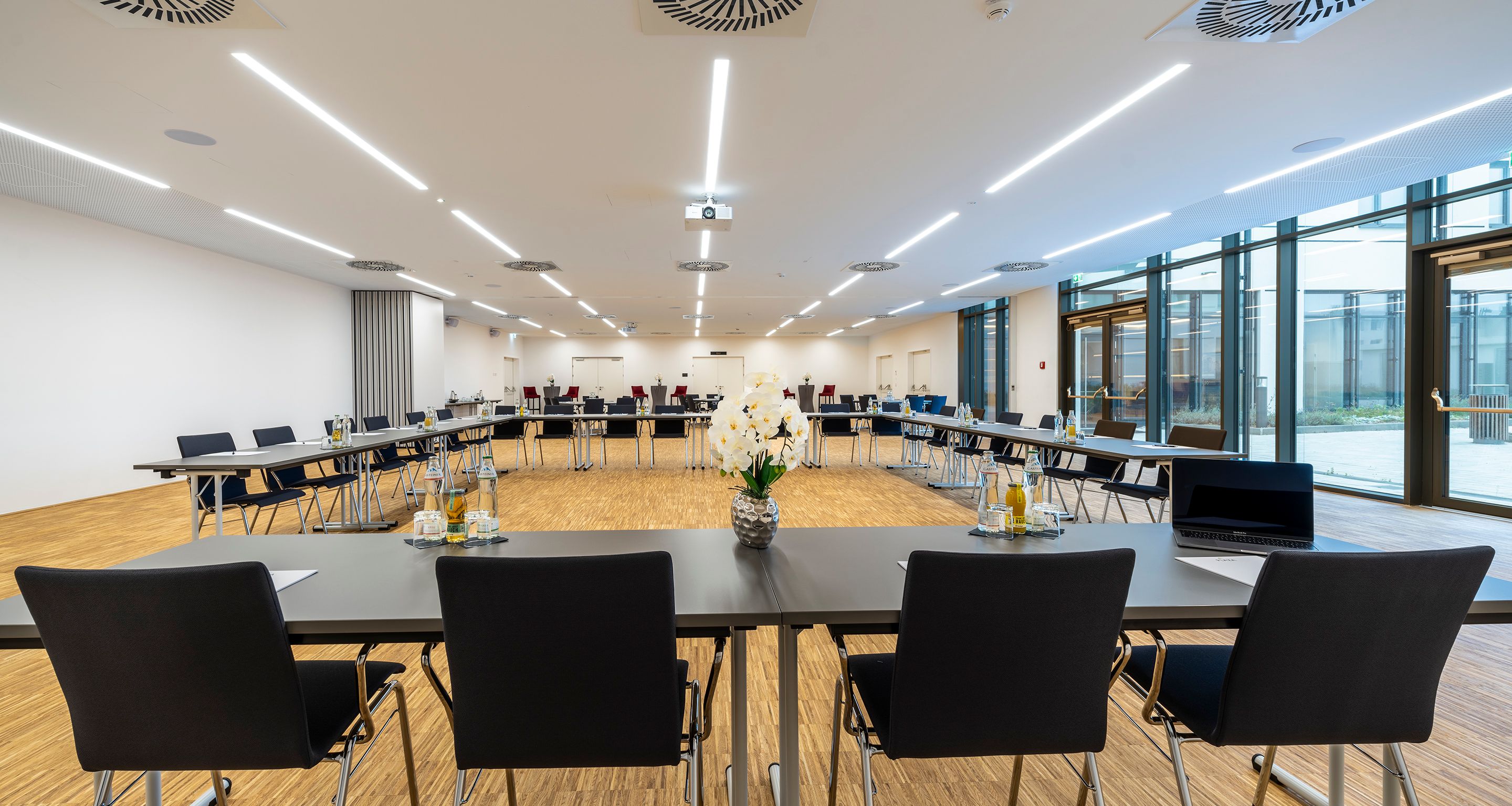 Large, bright room with black U-shaped seating 