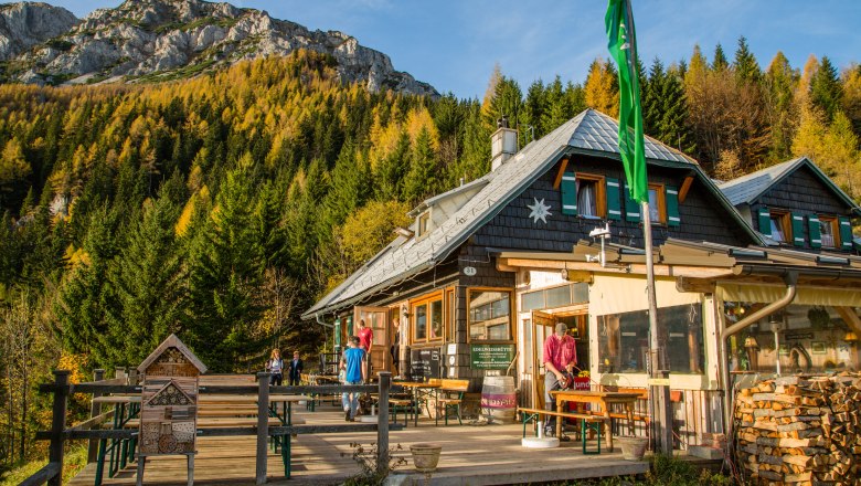 Edelweiss hut on Schneeberg with mountain scenery and forest in the background.