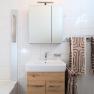 Modern bathroom with washbasin, mirror and towels.
