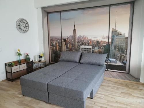 Room with gray sofa and photo wallpaper of New York skyline.