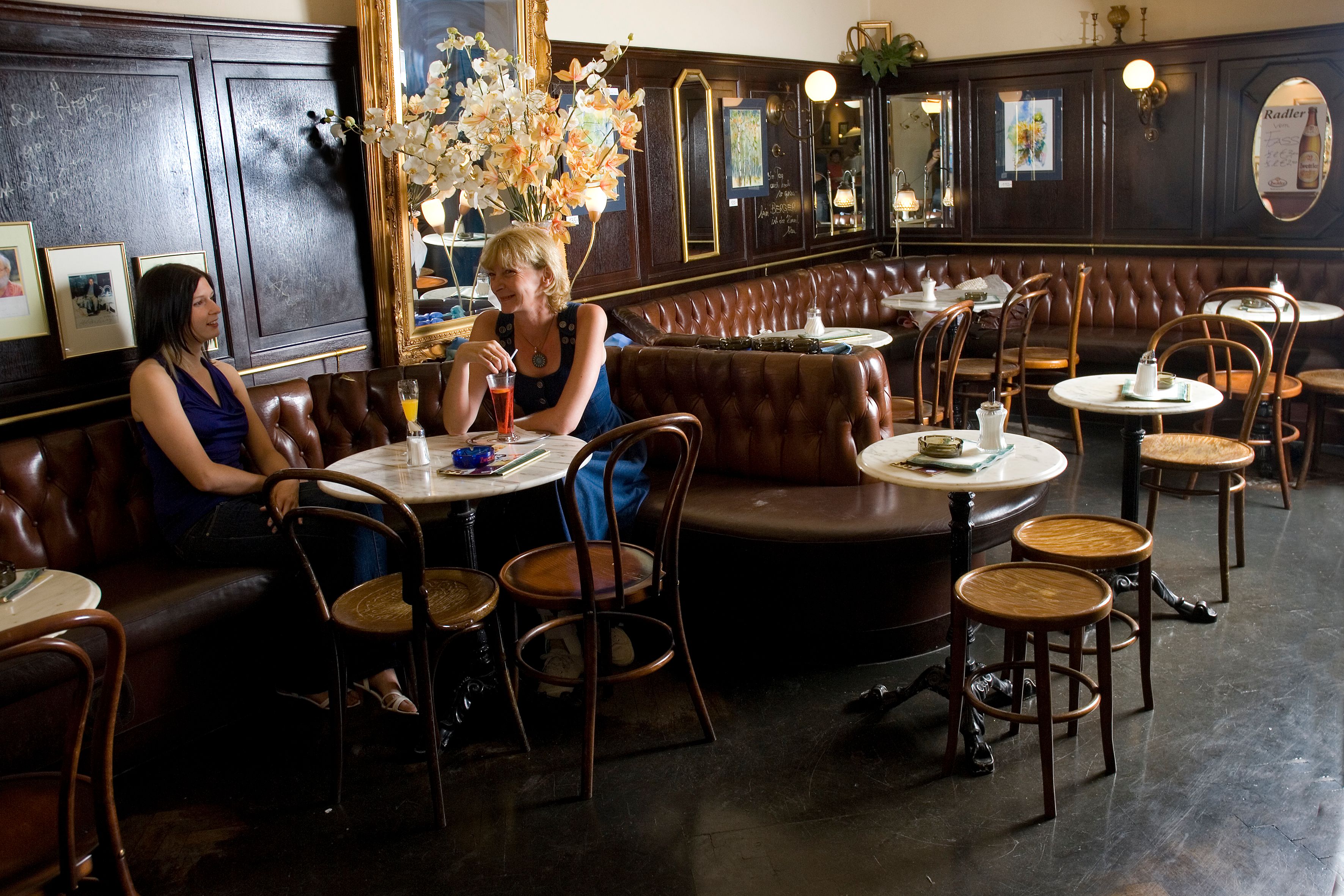 Interior view of a traditional café with two women sitting at a table.