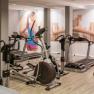 Fitness room with treadmills and fitness equipment, mural of a woman running.