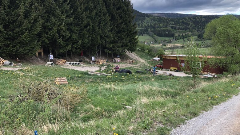 3D archery course in a forest landscape with targets and a building.