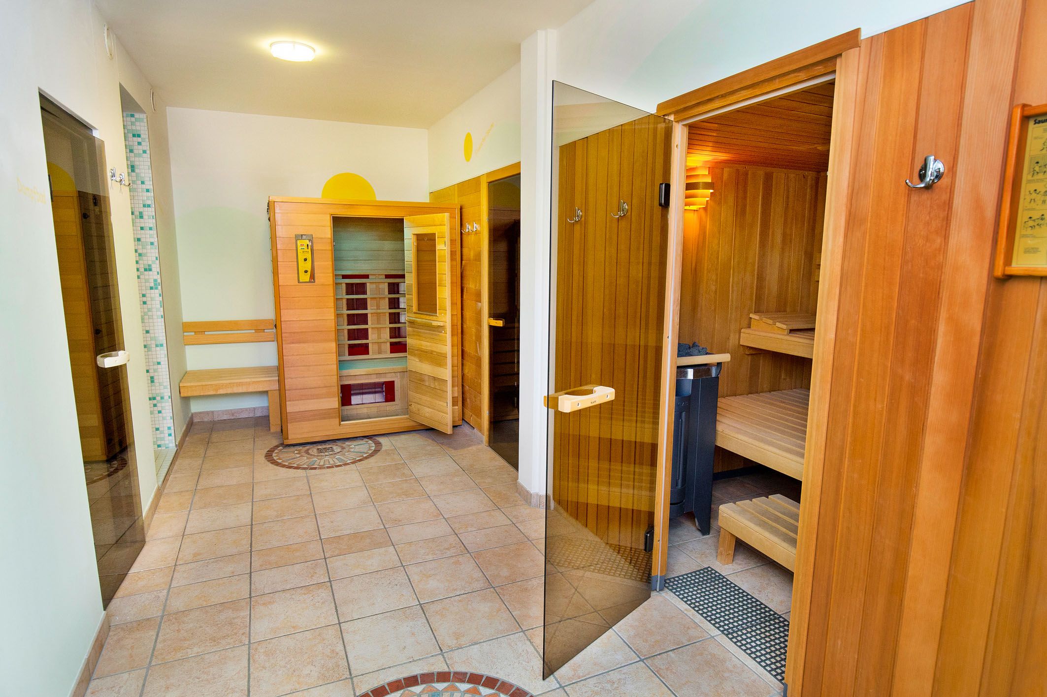 A modern sauna area with wooden walls and several sauna cabins.
