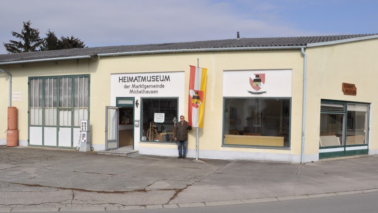 Exterior view of the Michelhausen local history museum with yellow building and flag.