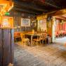 Interior view of a rustic hut with wooden furniture and decorations.