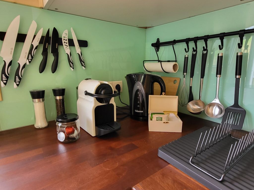 Kitchen worktop with coffee machine, kettle, spice grinders and kitchen utensils.
