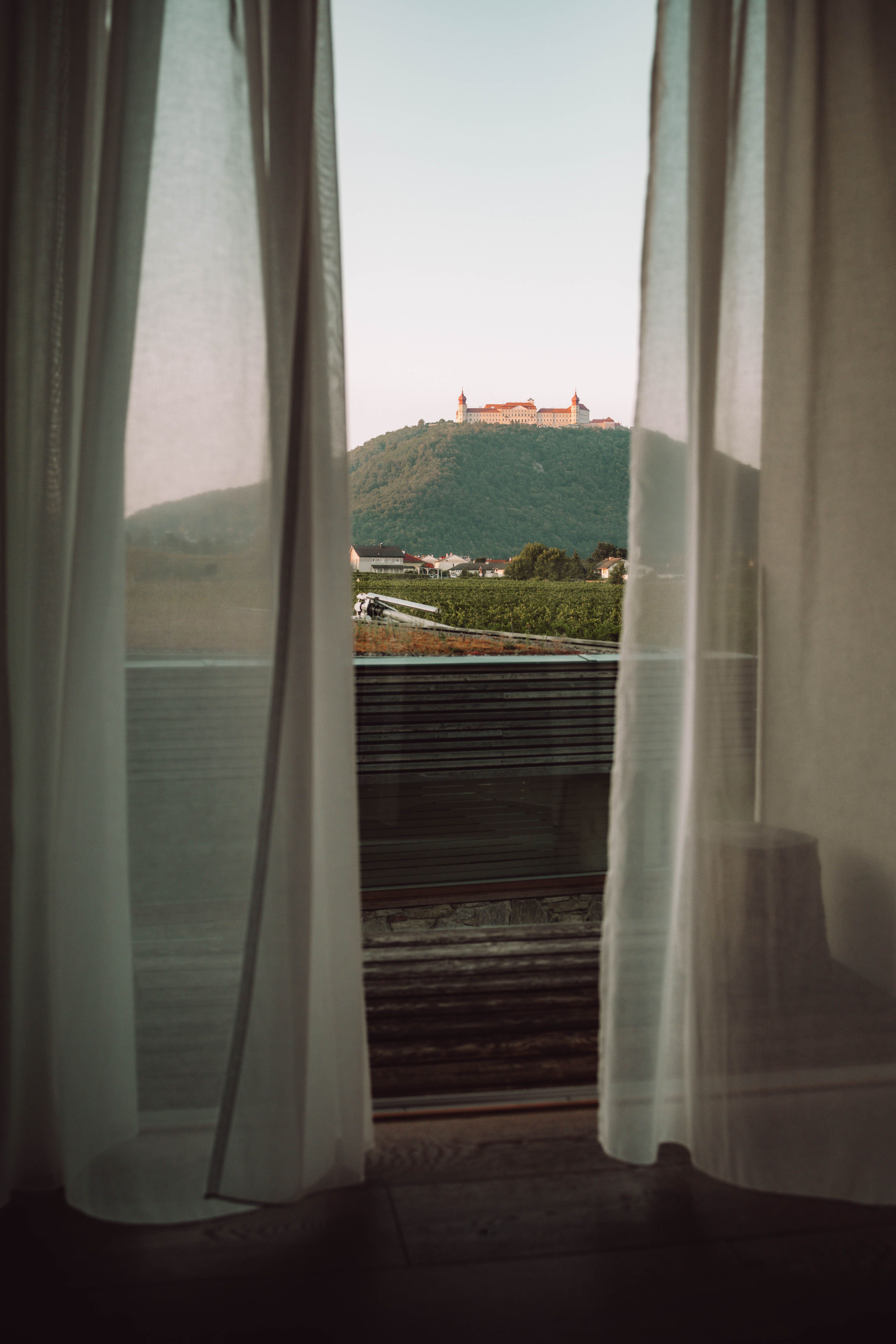 Exterior view of the MALAT winery and hotel with modern architecture and a vehicle in the foreground.