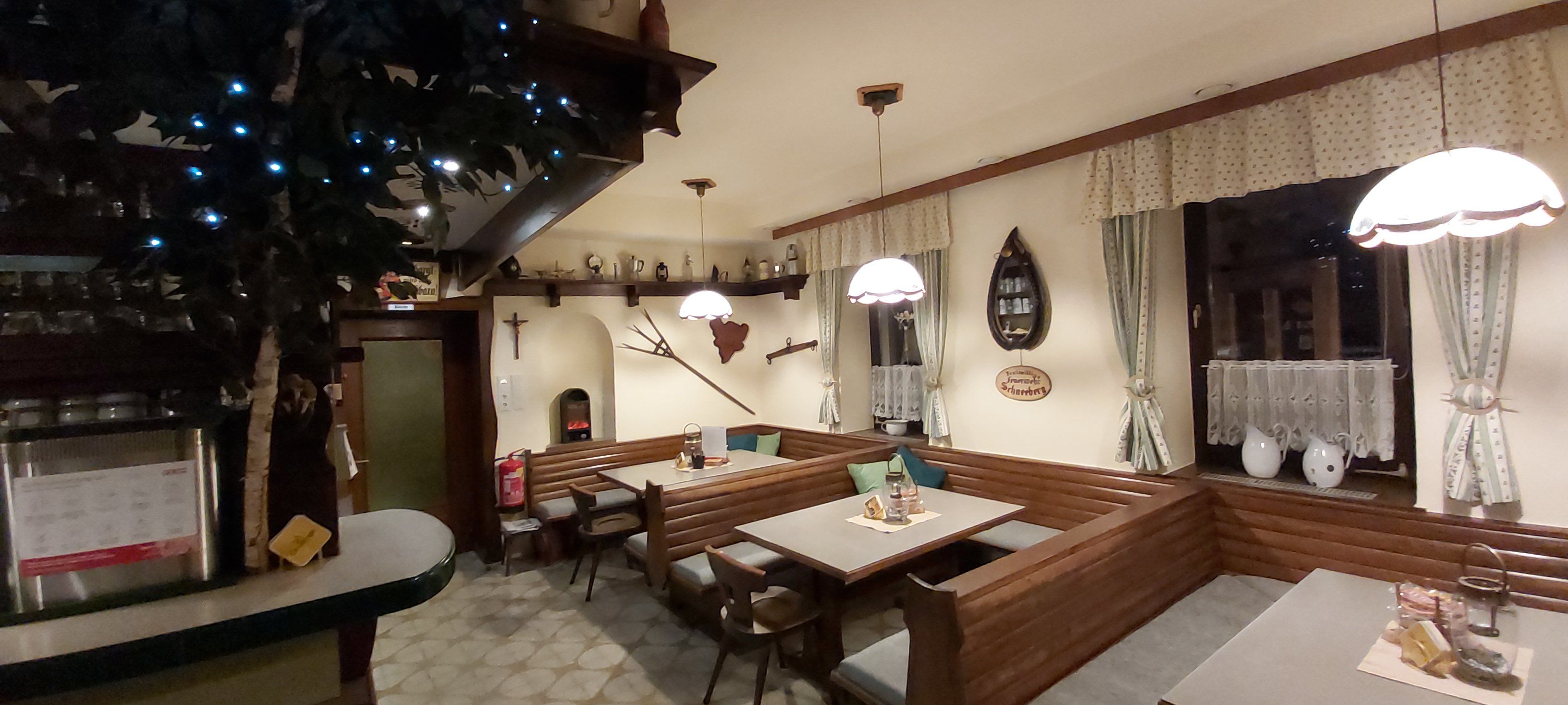 Cozy dining room with wooden furniture, decorative curtains and rustic accessories.