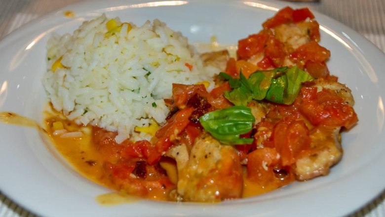 A plate of carp fillet with tomato and basil ragout and basmati rice.
