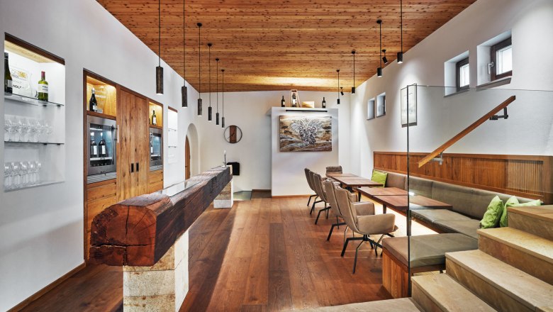 Interior view of a modern wine lounge with wooden elements, tables and chairs.