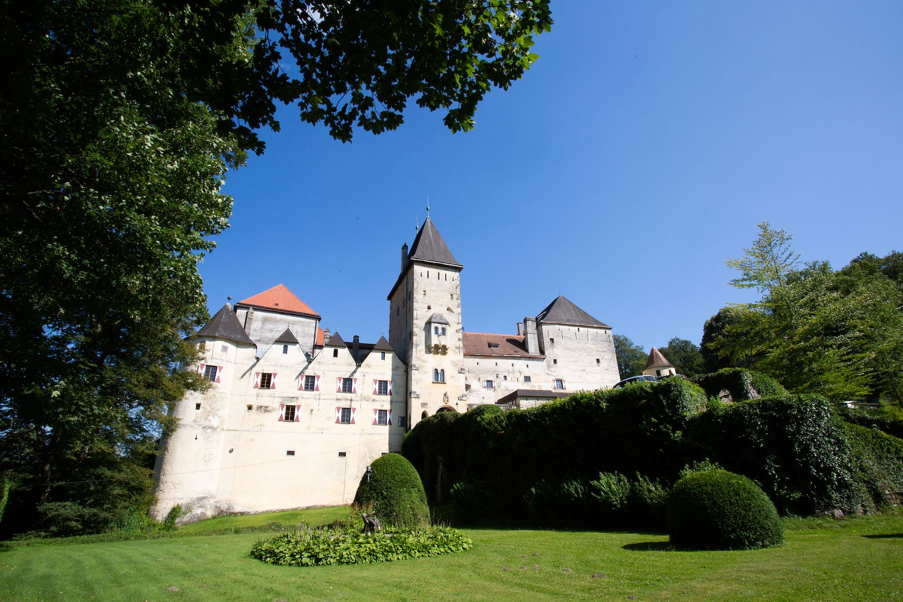 Feistritz Castle with blue sky and green landscape.