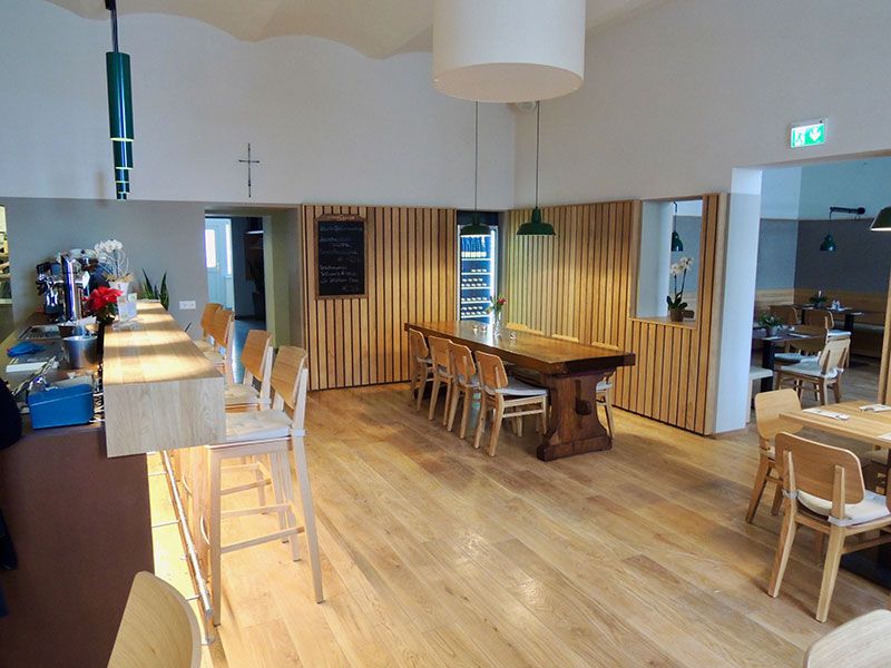 Interior view of a modern pub with wooden furniture and bar.