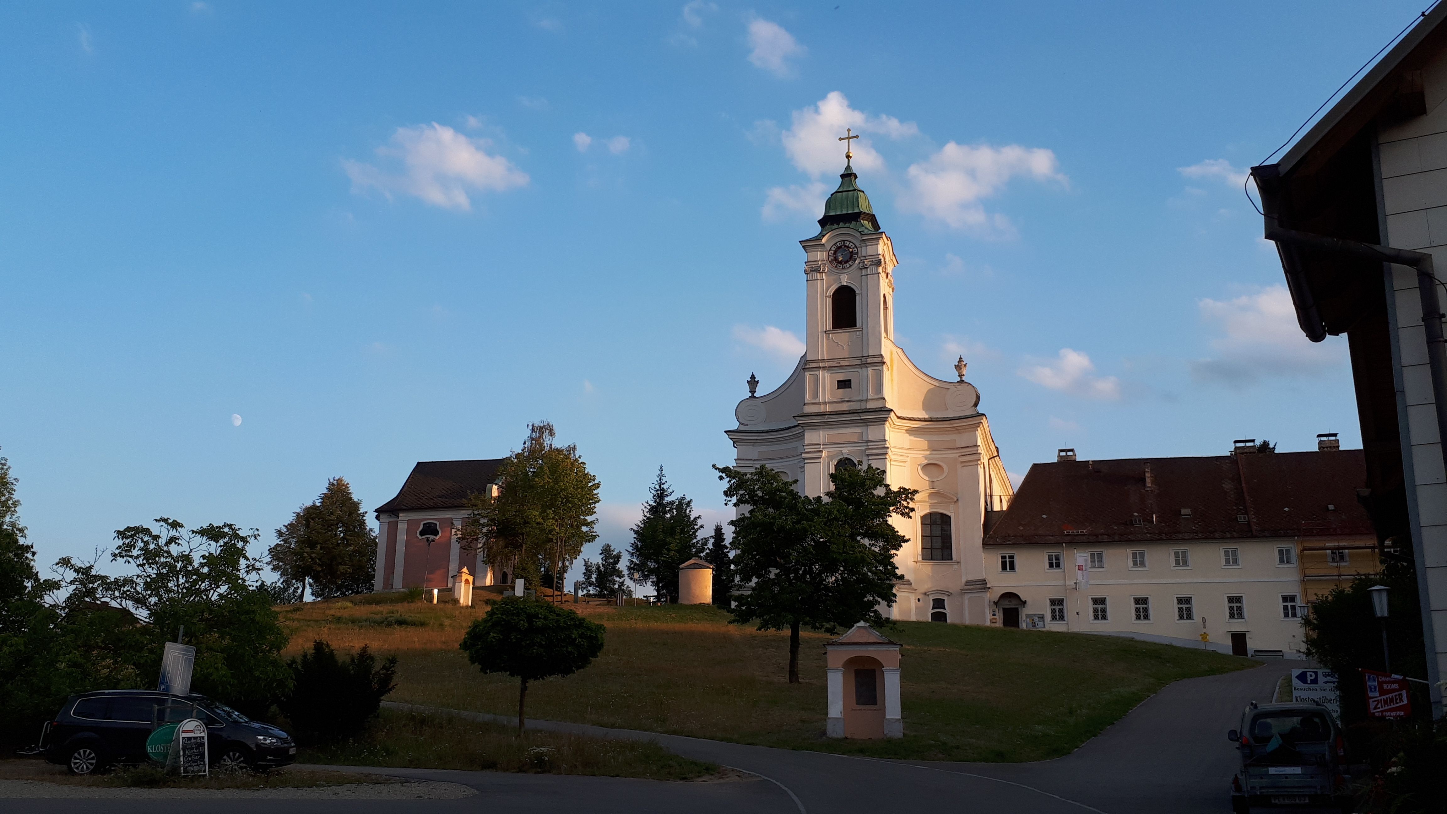 Church with tower and surrounding buildings at sunset.