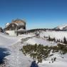 Winter landscape with the Ottohaus and snow-covered mountains in the background.