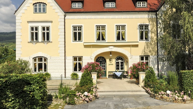 Yellow building with red roof and garden, Josef Jamek winery.