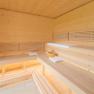 Interior view of a modern sauna with wooden benches and towels.