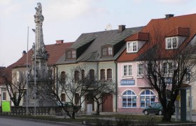 Street scene in Ebenfurth with historic buildings and a statue.