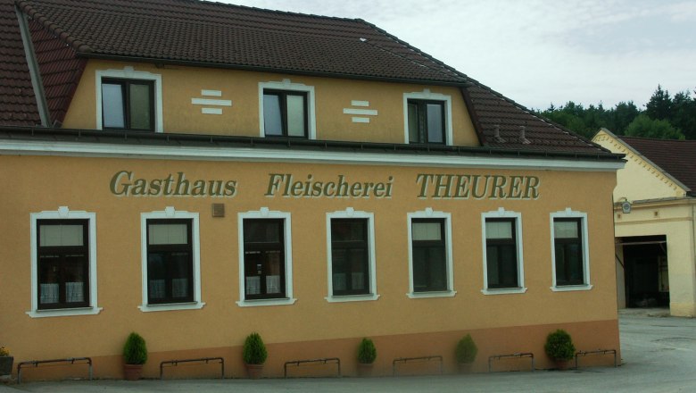 Exterior view of the Theurer inn and butcher's shop with yellow fa&ccedil;ade and brown roof.
