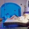Woman relaxing on a lounger in the wellness area with blue lighting.