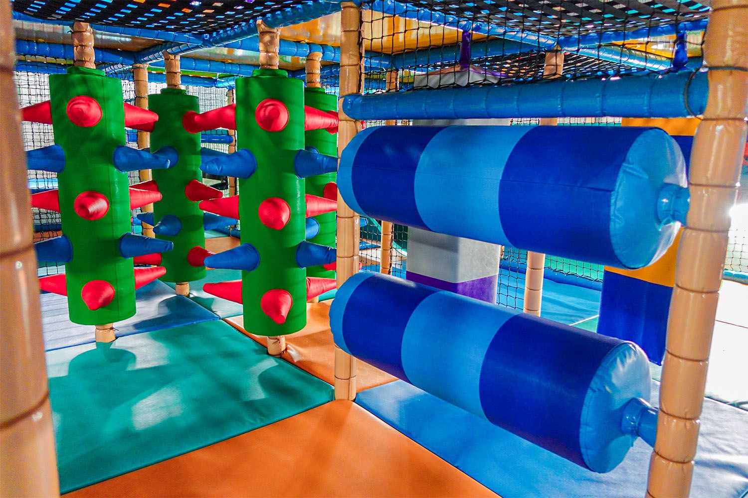 Colorful playground structure with green and blue obstacles.