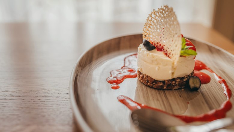 Mini cheesecake with strawberry coulis served on a plate.