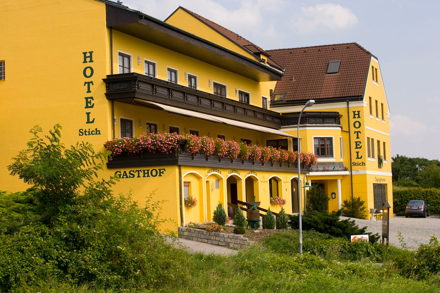Yellow hotel building with flowers on the balcony.