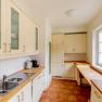 Bright kitchen with wooden worktops, white cupboards and large windows.