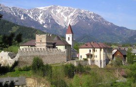 Puchberg castle ruins with snow-covered mountain in the background.