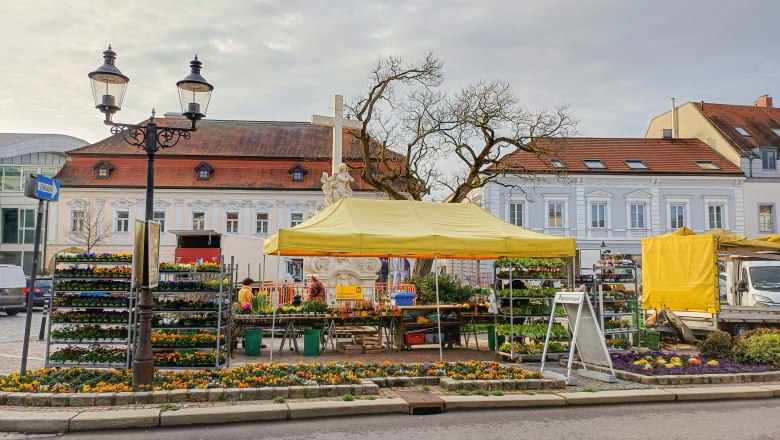 Weekly market in Stockerau with yellow tent and flower stalls.
