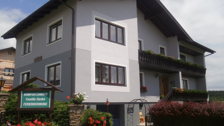 A two-storey guest house with balcony and garden.